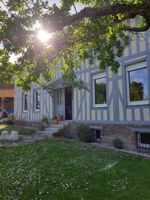 una casa blu e bianca con cortile di Chambre d'Hôtes des P'tits Bonheurs a Dosches