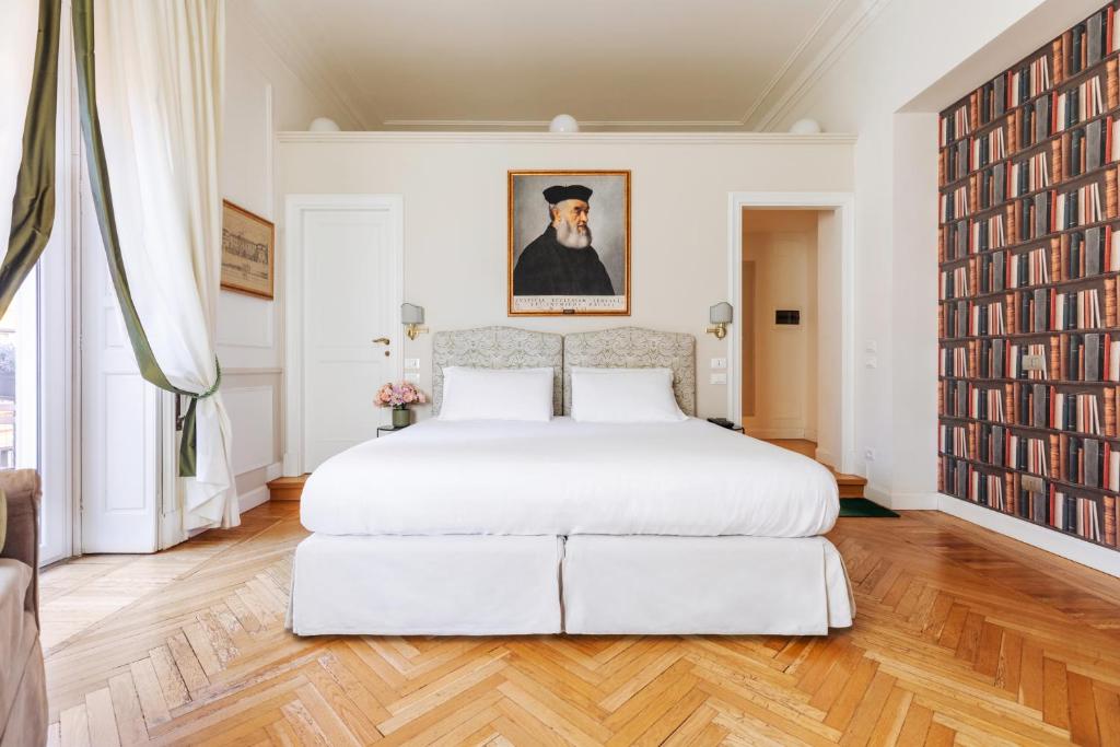 ein Schlafzimmer mit einem großen weißen Bett und einem großen Gemälde in der Unterkunft Relais Donna Lucrezia in Rom