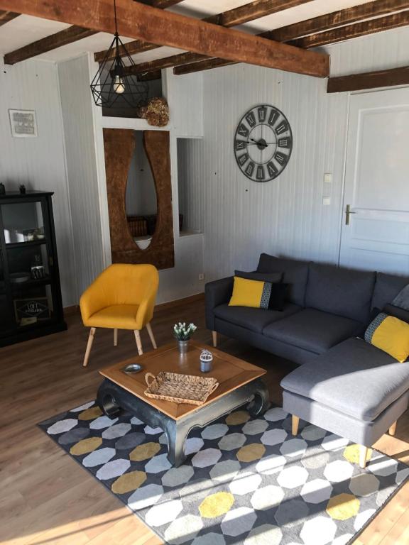 a living room with a couch and a table at Les Vieille tuiles in Cudos