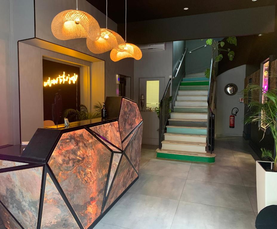 a lobby with a staircase and a table and chairs at Urban Jungle Hôtel Orleans in Orléans