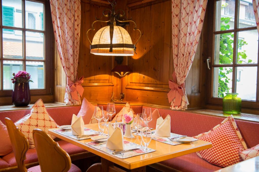 a dining room with a table and chairs and windows at Gasthaus Auerhahn in Baden-Baden