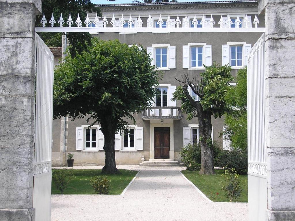 un arco que conduce a una casa grande con árboles en La Saudade en Saint-Péray