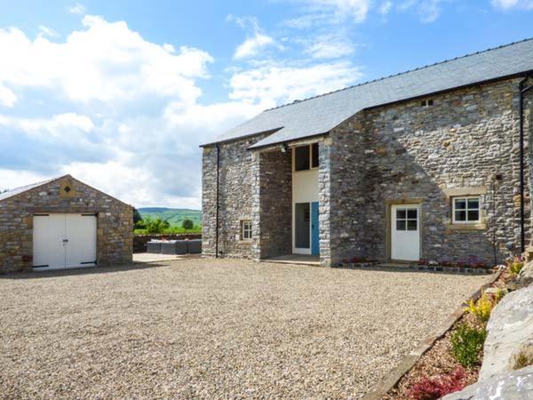 a stone house with a driveway in front of it at Ox Hey Barn in Bolton by Bowland