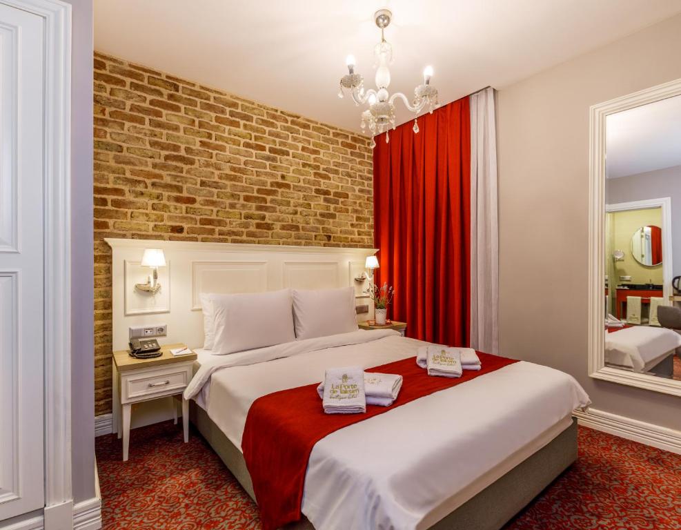 a hotel room with two beds and a red curtain at La Porte de Taksim in Istanbul