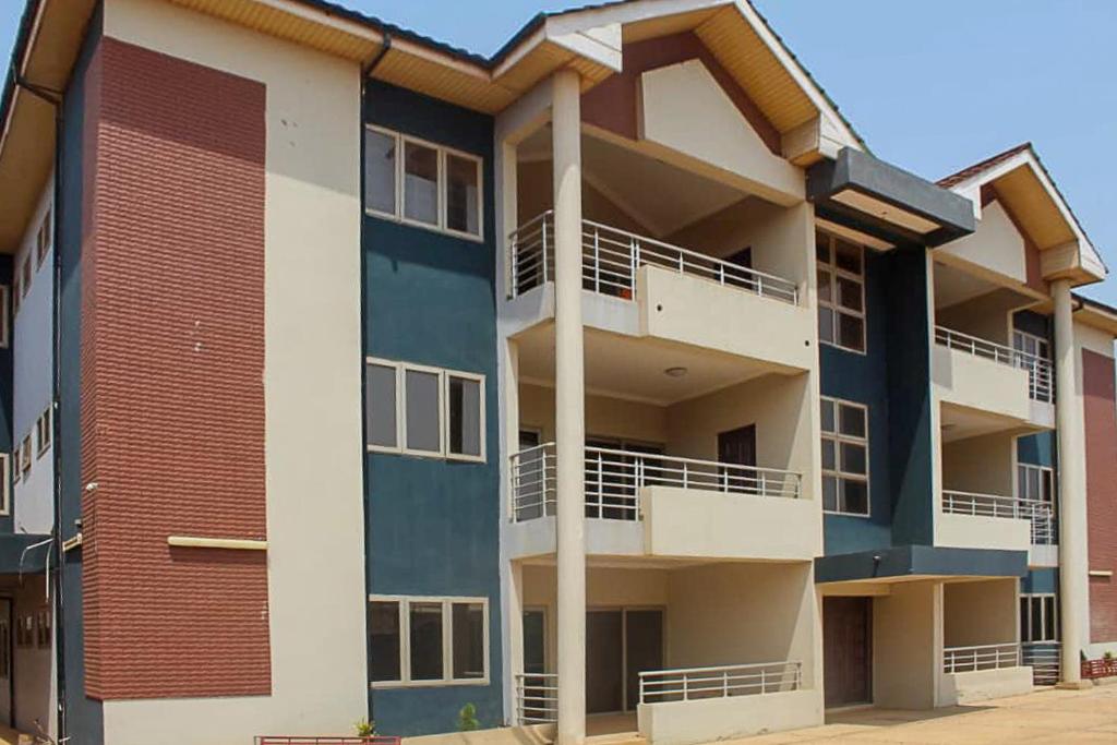 un immeuble d'appartements avec balcon sur le côté. dans l'établissement RESIDENCE IVOIRE, à Accra