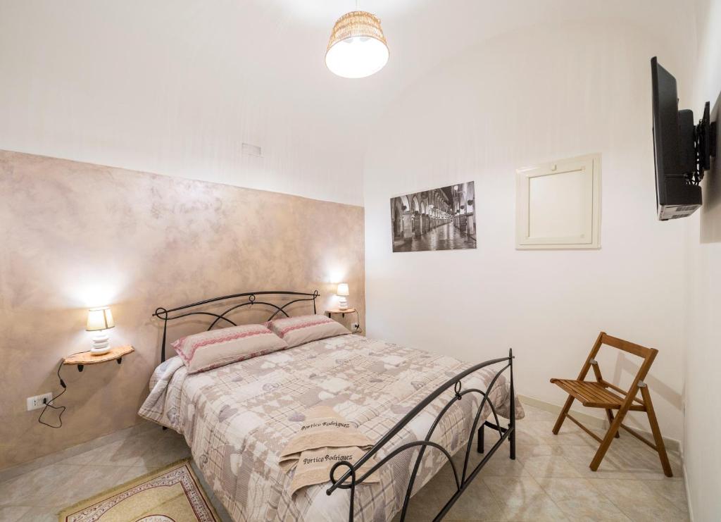 1 dormitorio con 1 cama, 2 mesas y 1 silla en Portico Rodriguez Cava de Tirreni, en Cava deʼ Tirreni
