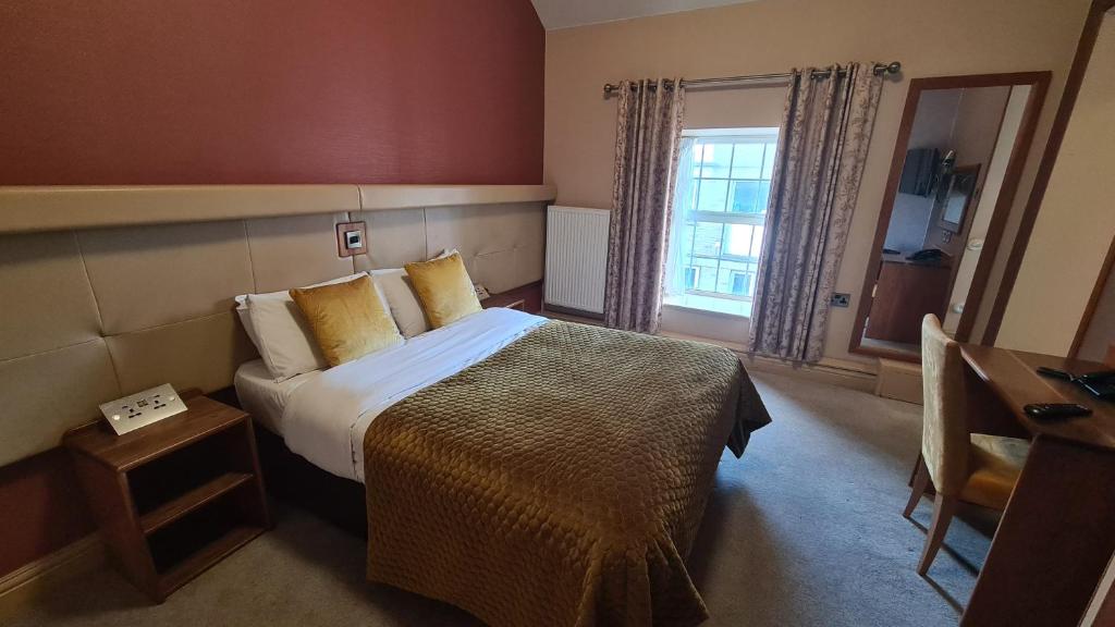 a bedroom with a large bed and a large window at The Farnham Arms Hotel in Cavan
