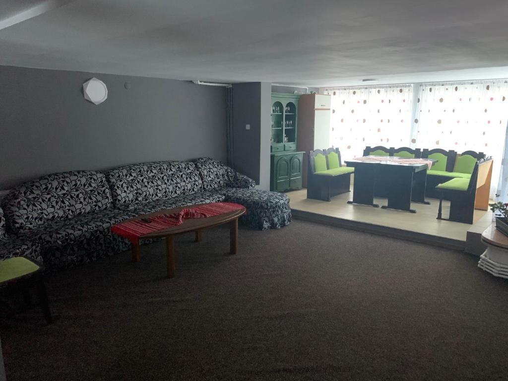 un soggiorno con un divano, un tavolo e delle sedie di Vila Azuga ad Azuga