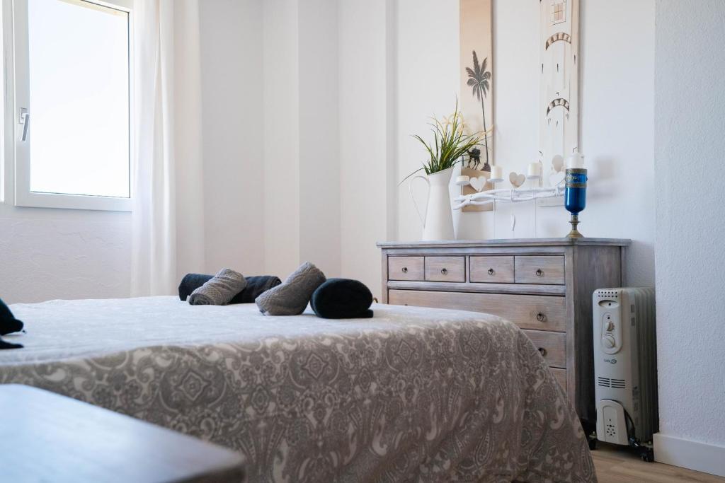 um quarto com uma cama com duas almofadas e uma cómoda em Tarifa Watersports Residence em Tarifa