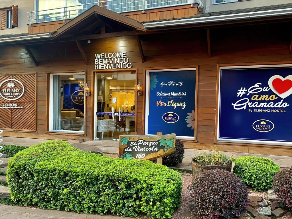 ein Restaurant mit Schildern auf der Vorderseite eines Gebäudes in der Unterkunft Eleganz Hostel & Suítes in Gramado