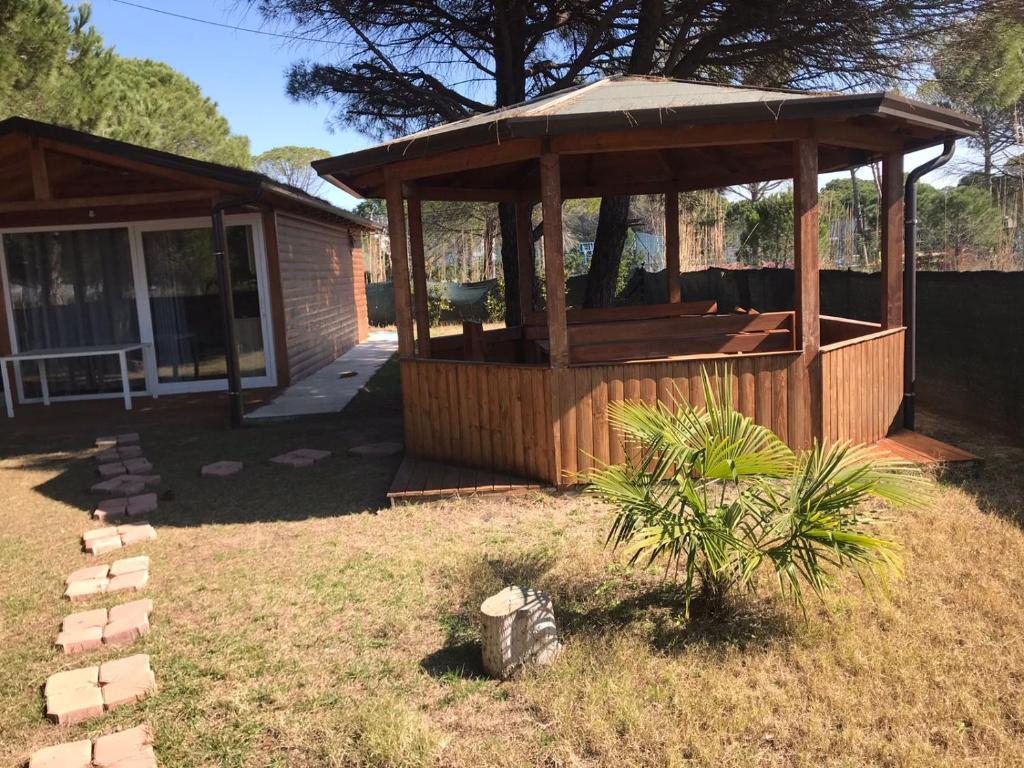 a wooden gazebo in a yard with a house at Vila Gjiri Lalzit in Durrës