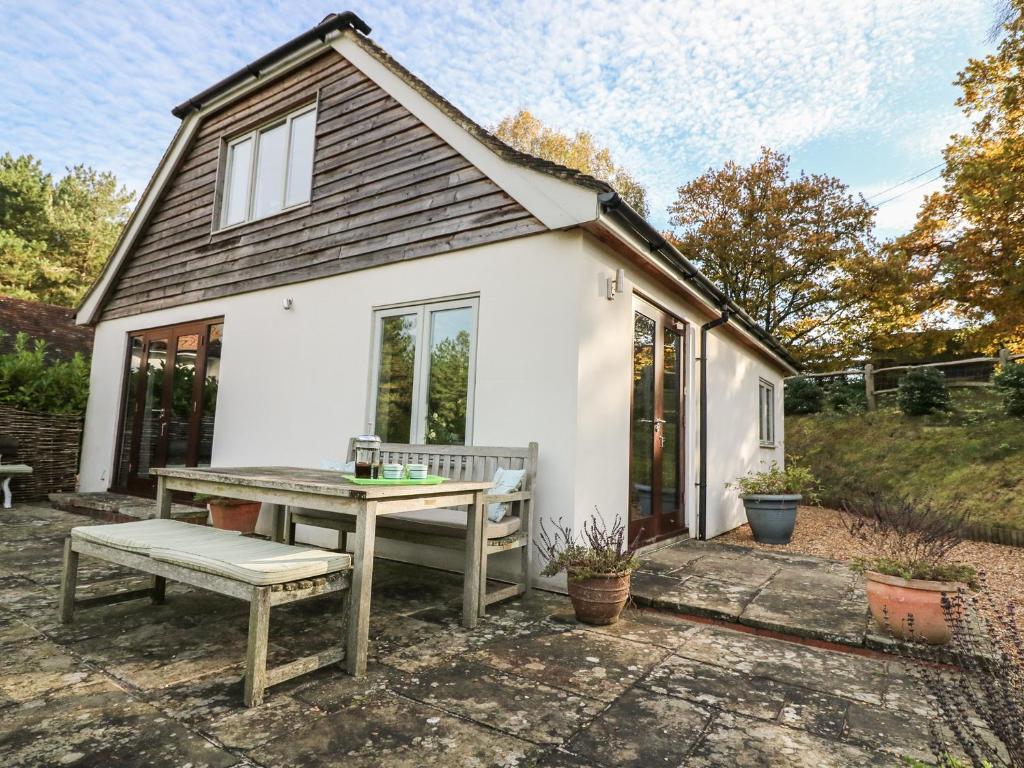 a small white house with a picnic table in front of it at Long Meadow in Heyshott