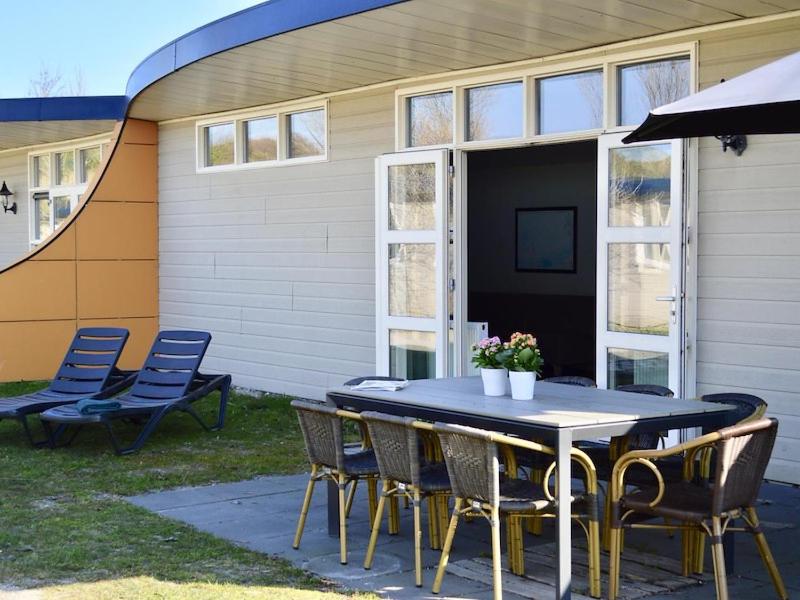 een tafel en stoelen voor een huis bij Bungalow 10 personen in 's-Gravenzande