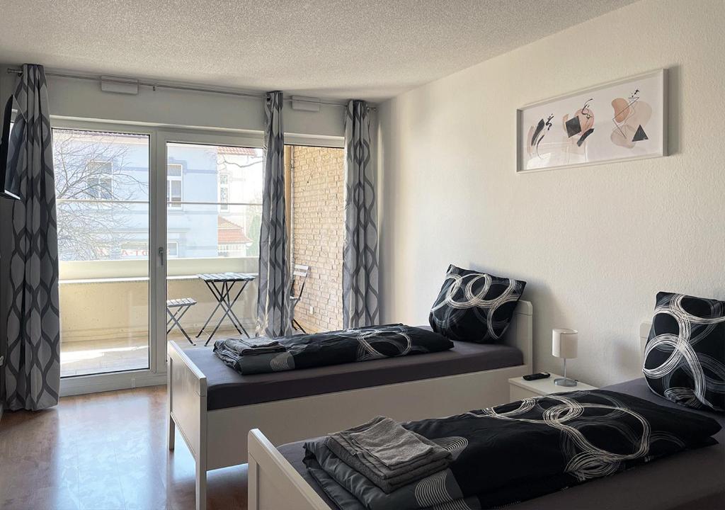 sypialnia z 2 łóżkami i balkonem w obiekcie Schönes Apartment im Herzen von Melle I home2share w mieście Melle