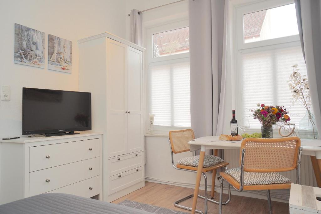 a bedroom with a tv and a table with chairs at Ferienwohnung Koje in zentraler Lage zum Schleswiger Dom in Schleswig