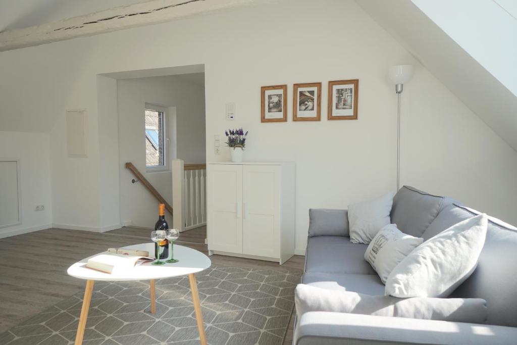 a living room with a blue couch and a table at Ferienwohnung - Unterm Dach in Schleswig
