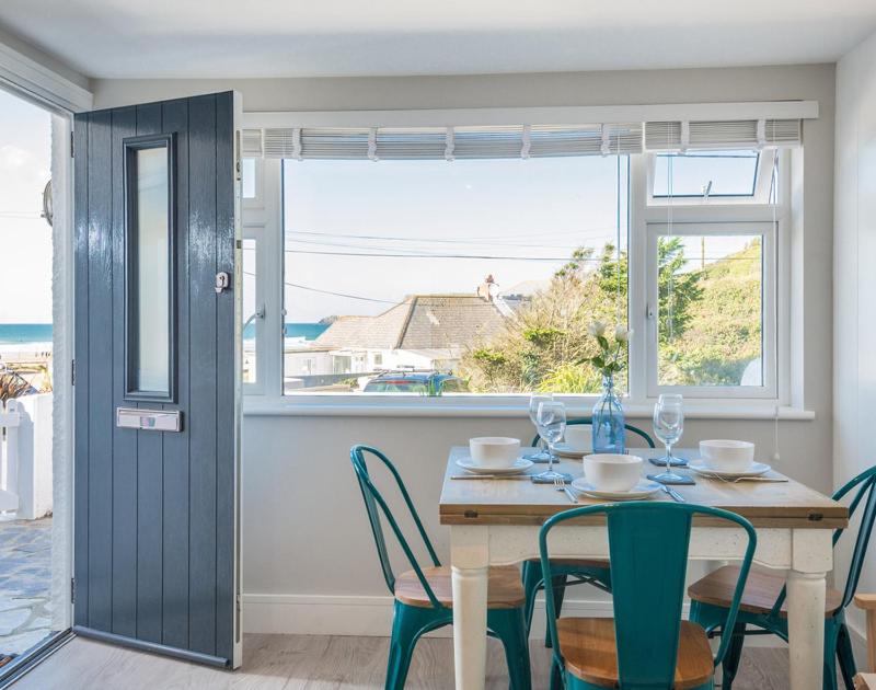 een eetkamer met een tafel en stoelen en een raam bij Tide Pod in Wadebridge