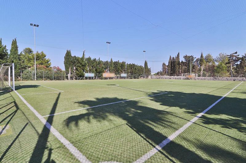 a tennis court with a tennis net on a field at HOTEL BARONE DI MARE in Torre dell'Orso