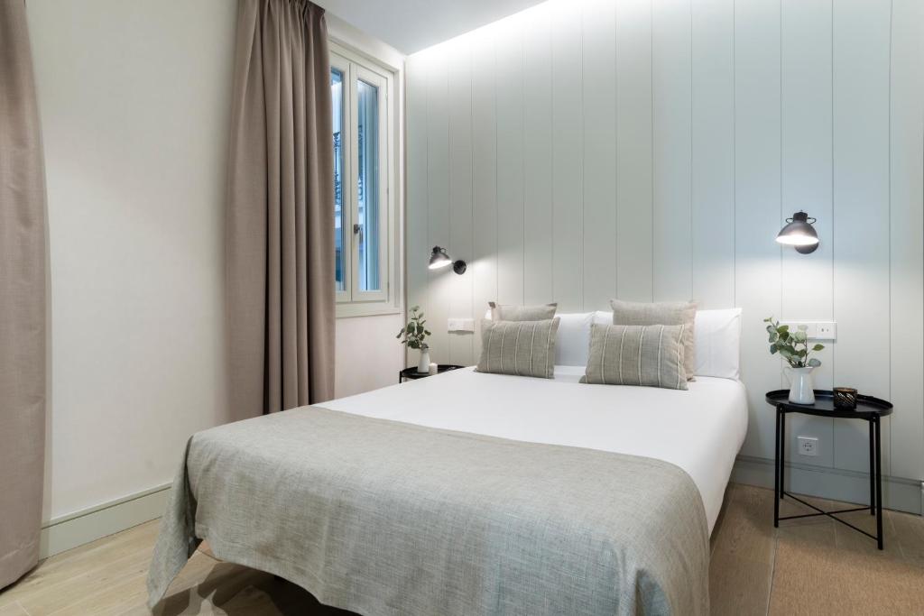 a white bedroom with a large white bed and a window at Prado Rooms 46 - Darya Living in Madrid