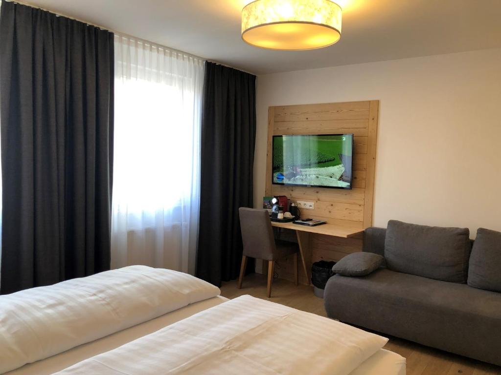 a bedroom with a bed and a desk and a couch at Württembergischer Hof in Kirchheim unter Teck