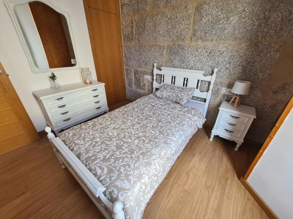 a bedroom with a bed and a dresser and a mirror at Casa Fidalgo in Ribadavia