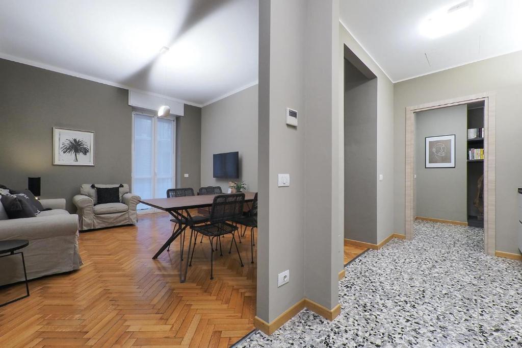 uma sala de estar com uma mesa e um sofá em Contempora Apartments - Cavallotti 13 - B23 em Milão