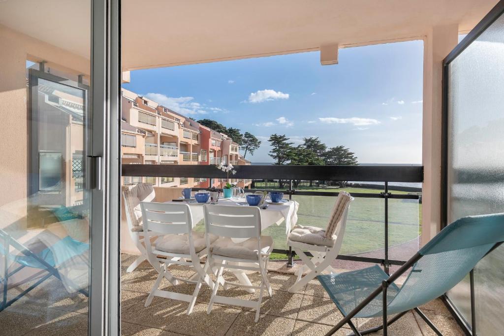 a patio with a table and chairs on a balcony at Face Mer appartement pour 4 personnes in Pornic