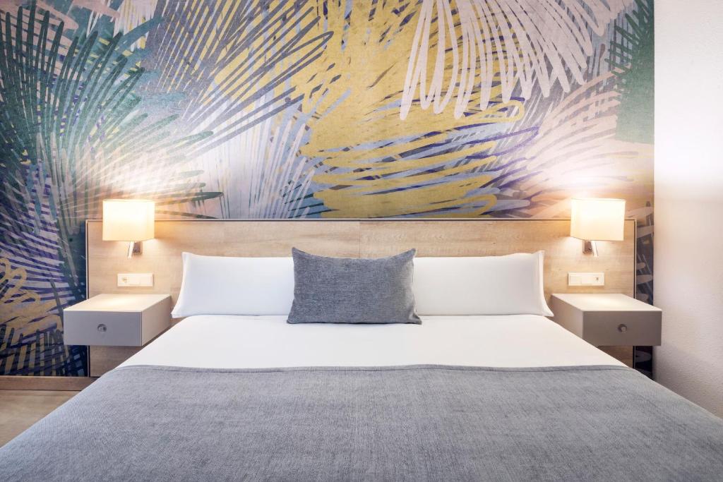 a hotel room with a bed and a painting on the wall at Salles Ciutat del Prat Barcelona Airport in El Prat de Llobregat