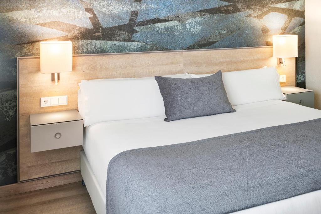 a bedroom with a bed and a painting on the wall at Salles Ciutat del Prat Barcelona Airport in El Prat de Llobregat