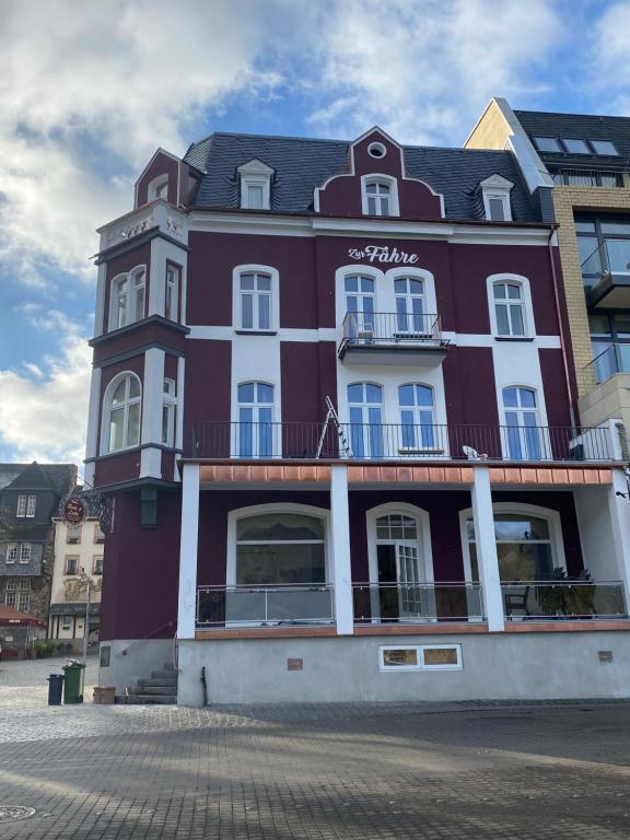 a large red building with white trim on a street at Pension Zur Fähre in Boppard