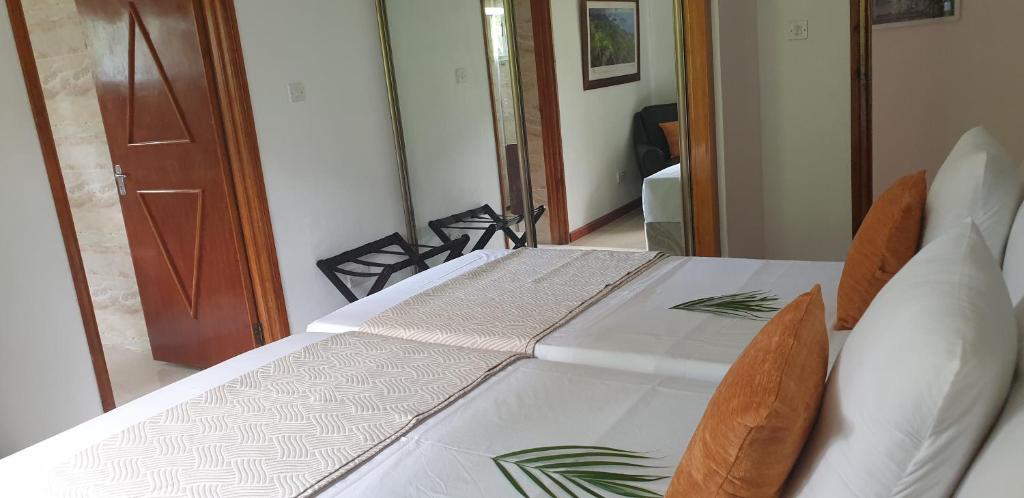uma mesa com duas cadeiras e uma toalha de mesa branca em Chrisent Residence em Port Glaud