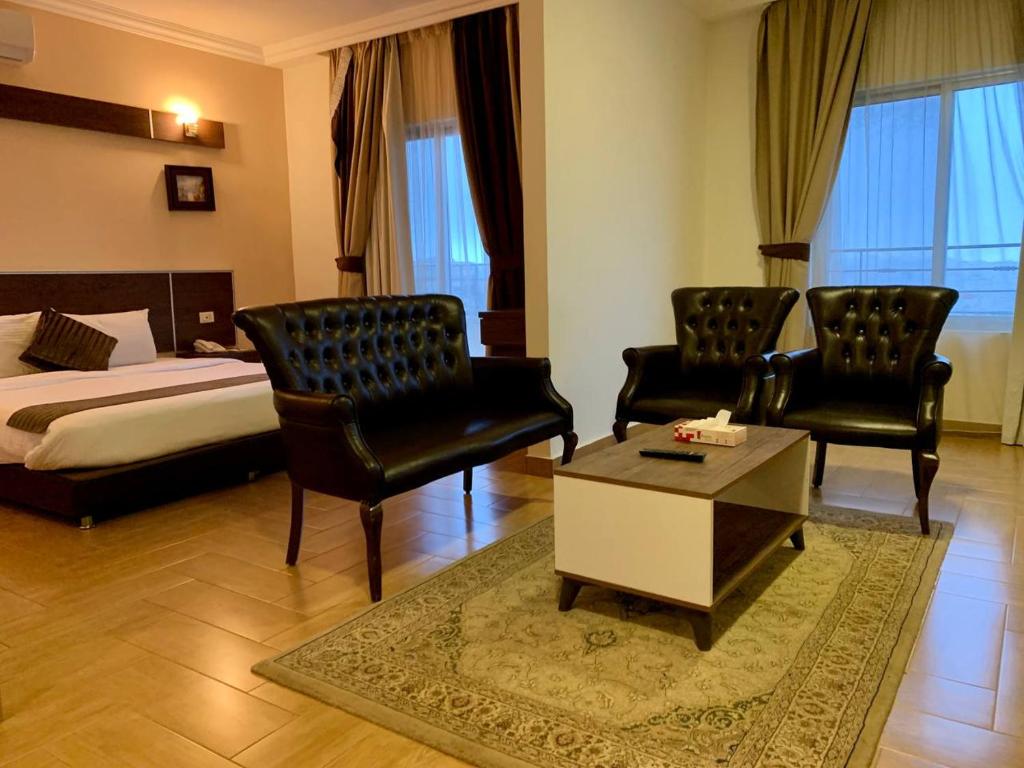 um quarto de hotel com uma cama e duas cadeiras e uma mesa em Ream Hotel Amman em Amã