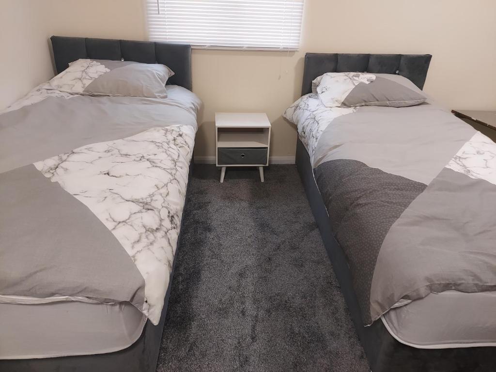 two beds sitting next to each other in a bedroom at 2-Beds Studio Located in Parkgate Rotherham in Rotherham