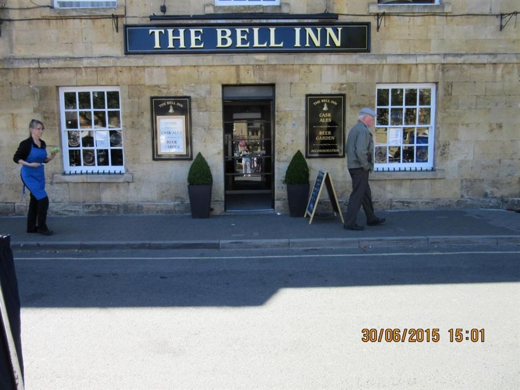 a man and a woman standing outside of a building at The Bell Inn in Moreton in Marsh