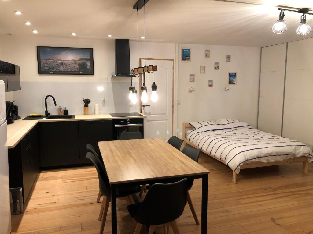 cocina y dormitorio con mesa y cama en La Bicoque d'Opale à deux pas de la plage, en Ambleteuse