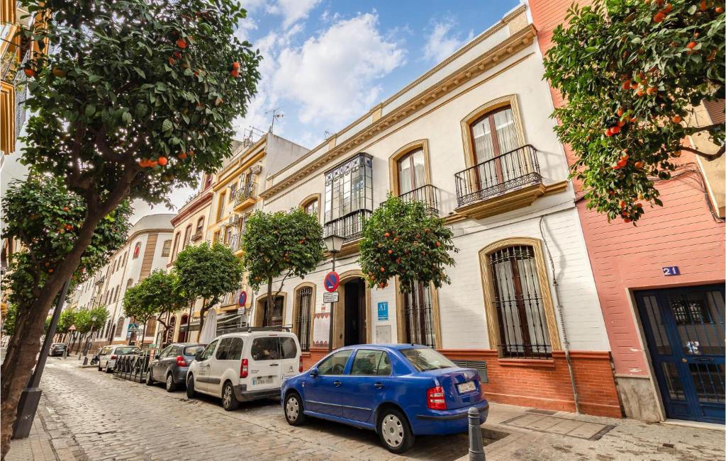 a blue car parked on a street next to buildings at Stunning Apartment In Sevilla With Wifi in Seville