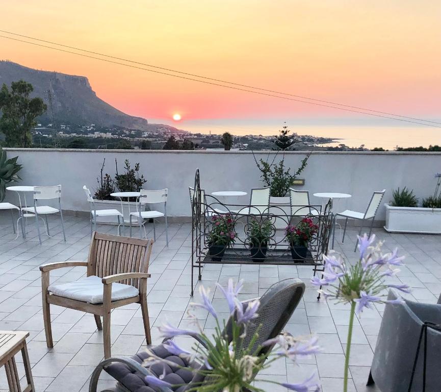 a patio with tables and chairs and a sunset at Casale Belvedere vista mare in Valderice