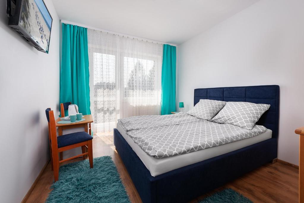 ein Schlafzimmer mit einem Bett, einem Stuhl und einem Fenster in der Unterkunft Dom Wypoczynkowy Arka in Jastrzębia Góra