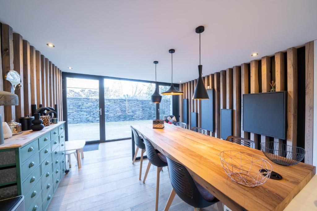 a kitchen with a long wooden table and chairs at Gîtesdesignemoi entre Design et émotion - la perle in Onhaye