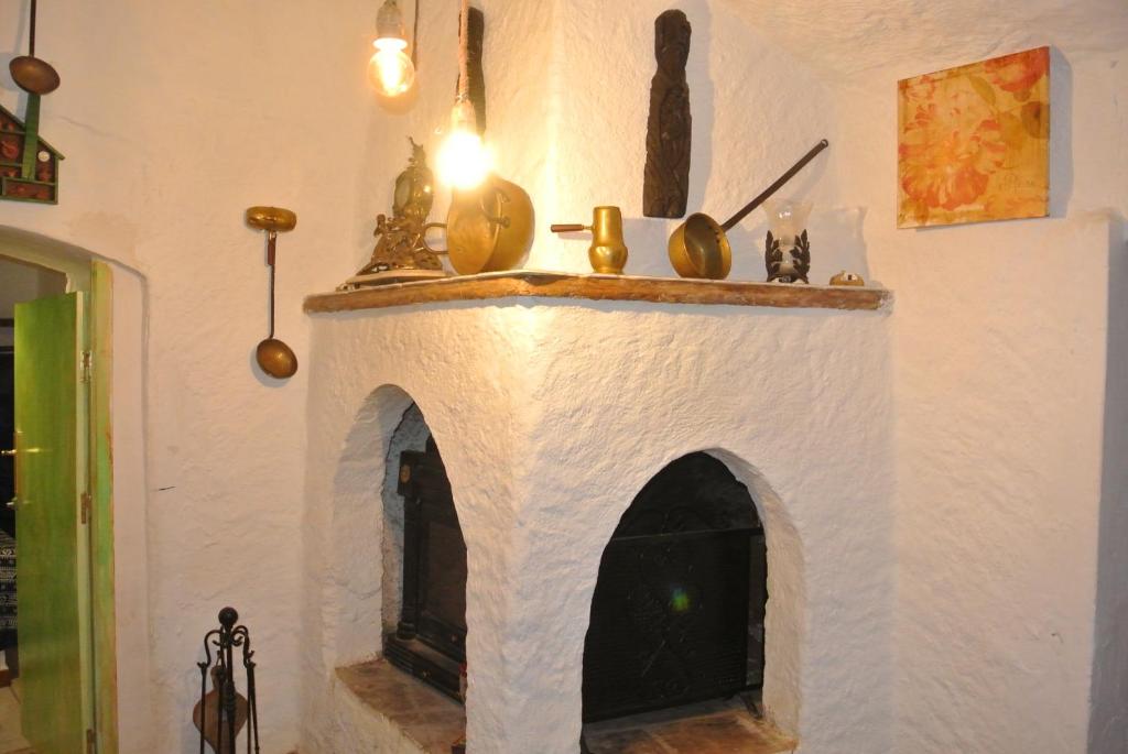 a fireplace in a room with a white wall at Casa cueva El Algarrobo in Guadix