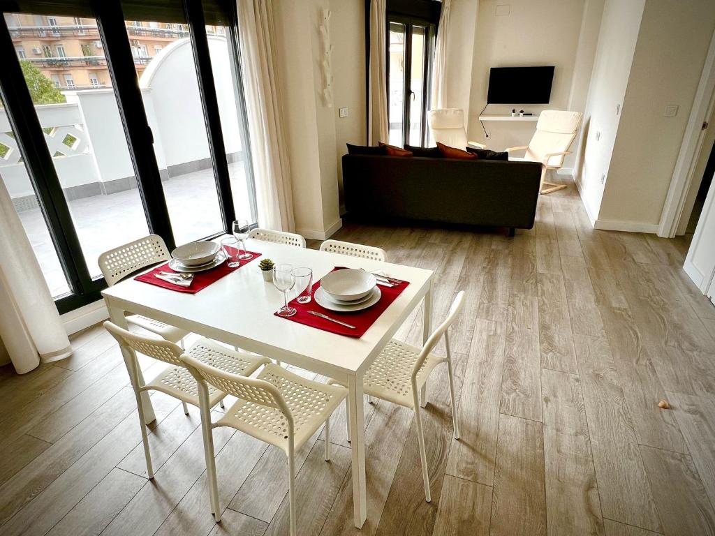 einen weißen Tisch und Stühle im Wohnzimmer in der Unterkunft El balcón de Ciudad Jardín in Córdoba