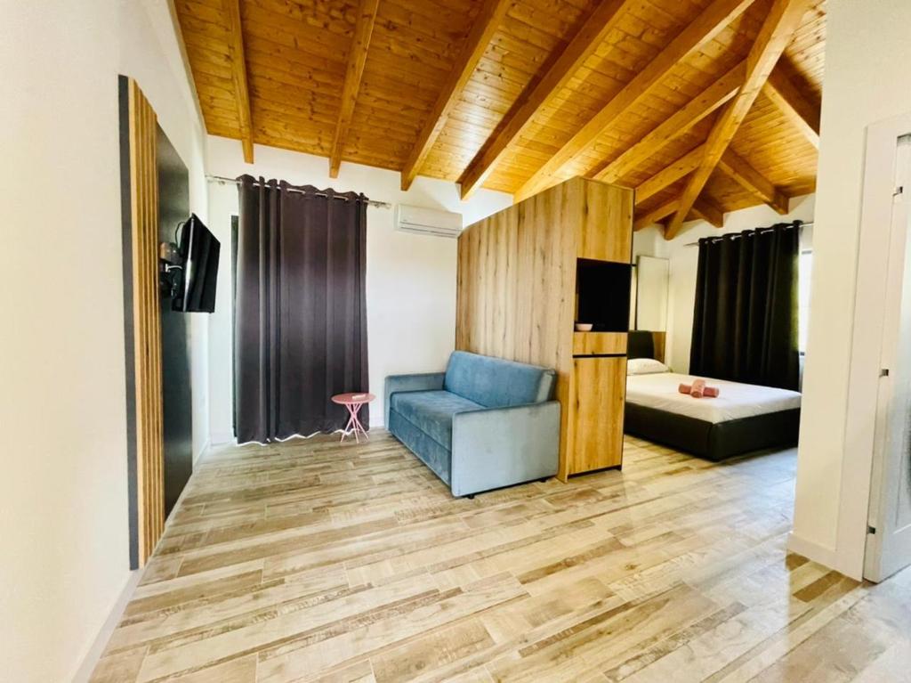 uma sala de estar com um sofá azul e uma cama em ADRIATIK Hotel em Vlorë