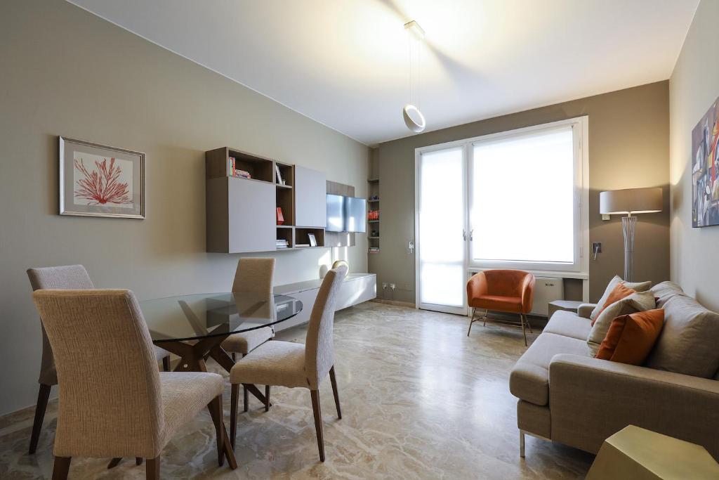 salon ze stołem, krzesłami i kanapą w obiekcie Contempora Apartments - Elvezia 8 - E51 w Mediolanie