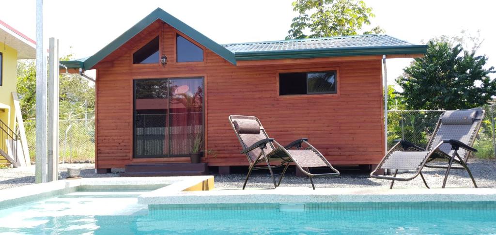 a couple of chairs sitting next to a tiny house at Cabaña Tio King in Uvita