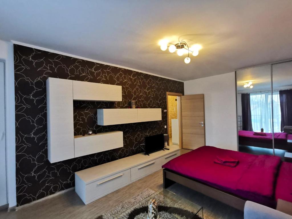 una camera con un letto rosso e una parete nera di Contemporary central apartment in Cluj Napoca a Cluj-Napoca