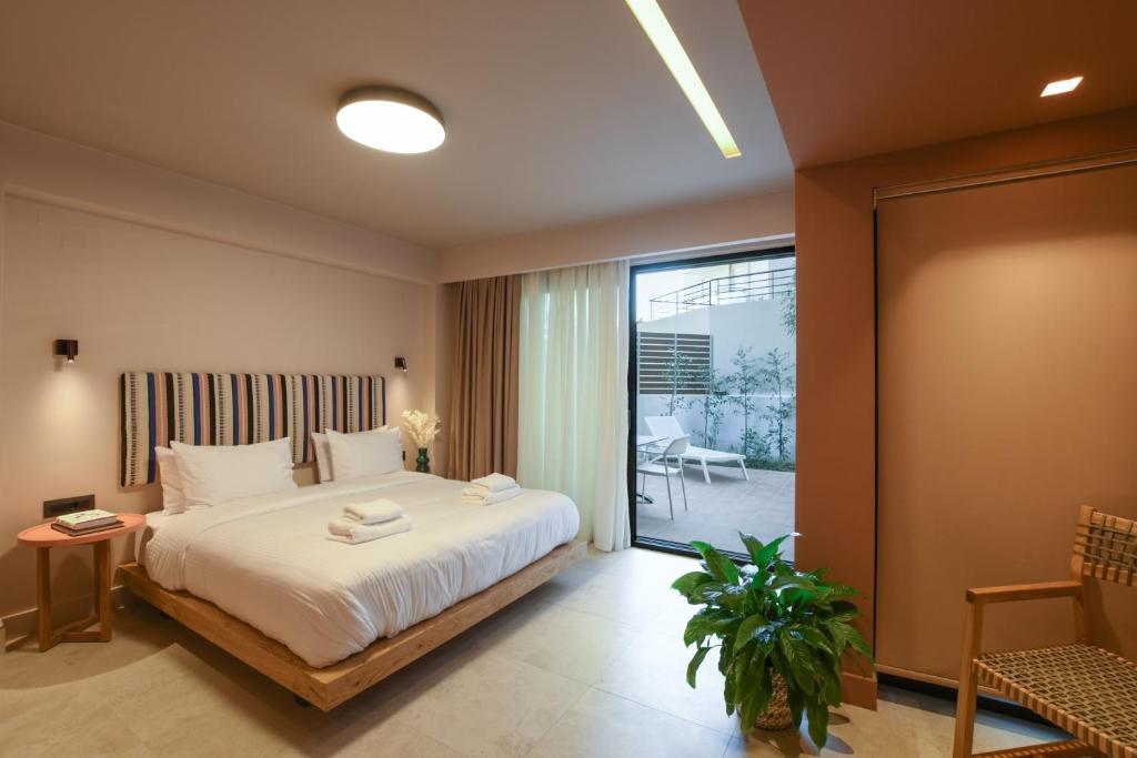 イラクリオン・タウンにあるPavo Art Hotelのベッドとガラスの引き戸のある寝室
