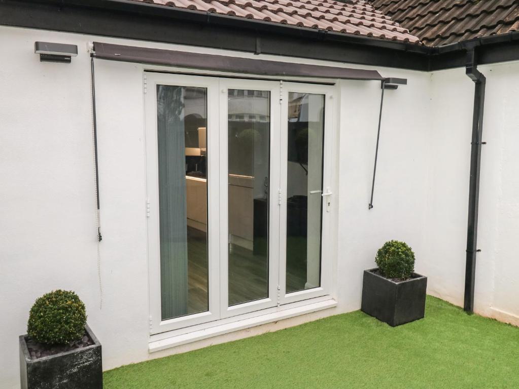 a sliding aluminium door on a white house with grass at Sunnydene in Paignton