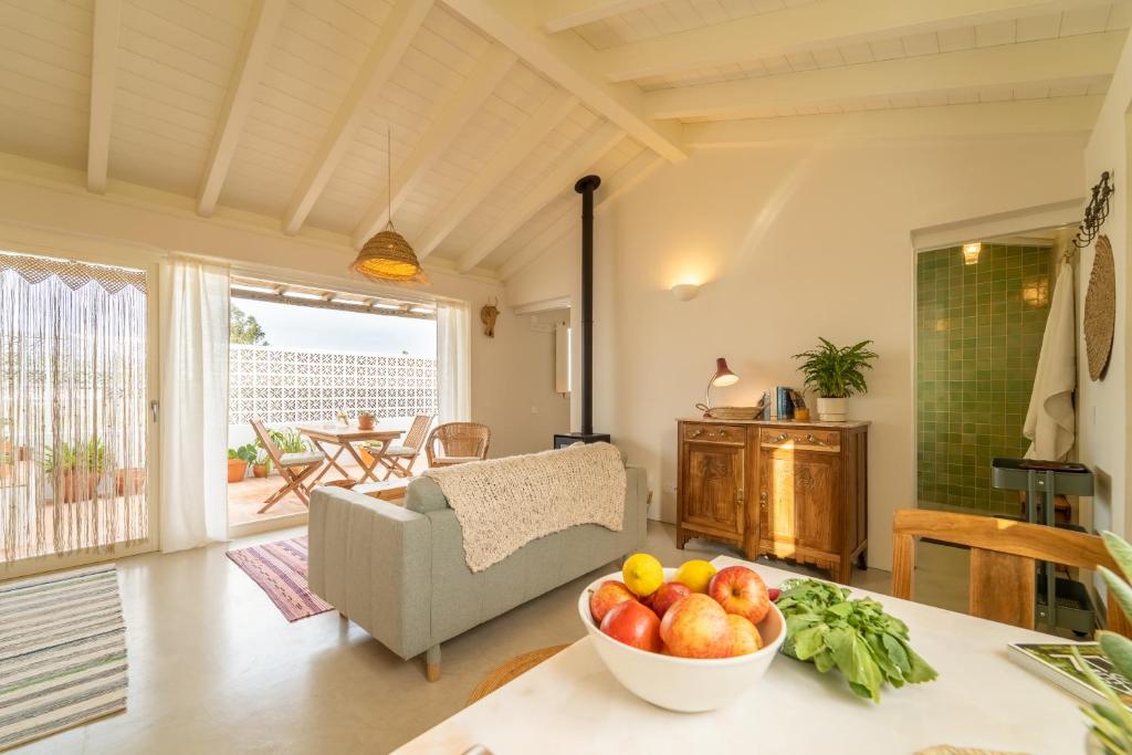a living room with a bowl of fruit on a table at Casinha da Cabra, Casas do Poente, Rogil, Aljezur in Aljezur