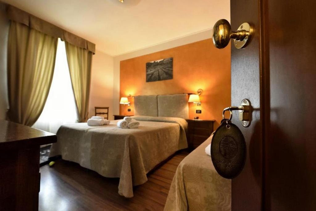 Postel nebo postele na pokoji v ubytování Hotel Arcobaleno Siena