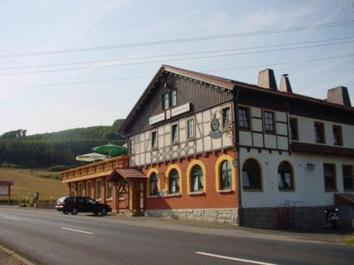 a building on the side of a road next to a street at Hotel Brückenmühle in Meiningen